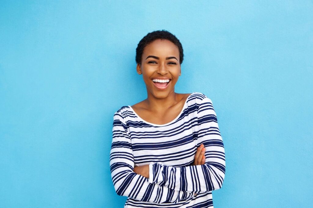 A woman smiling with her arms crossed.